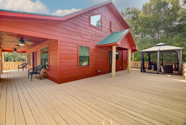 a view of a house with wooden deck and furniture