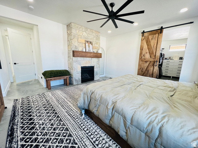 100 Whit Lane Georgetown, ID 83239 - Photo 25 of 76 Bedroom with a barn door, a stone fireplace, a ceiling fan, and recessed lighting