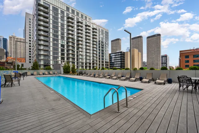 a swimming pool with outdoor seating and wooden floor