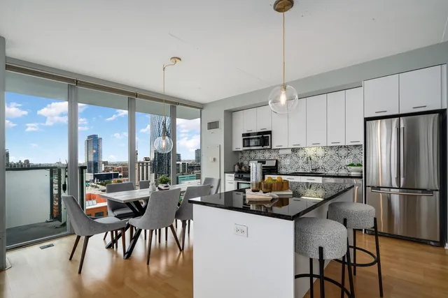 a kitchen with a table chairs refrigerator and microwave