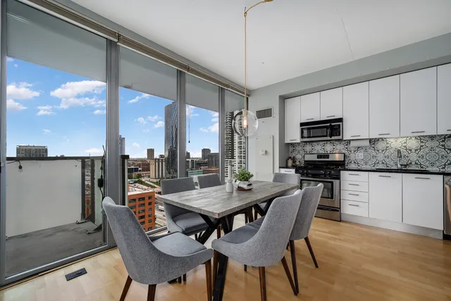 a dining room with furniture a chandelier and wooden floor