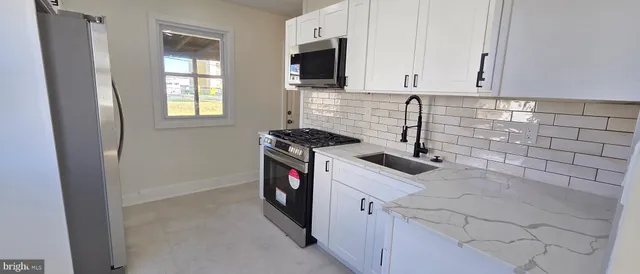 a kitchen with granite countertop a sink and a stove top oven