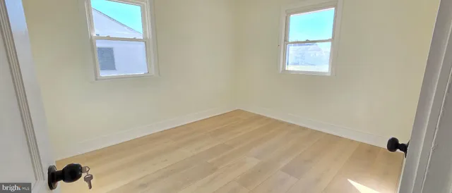 a view of a small space with wooden floor and a window