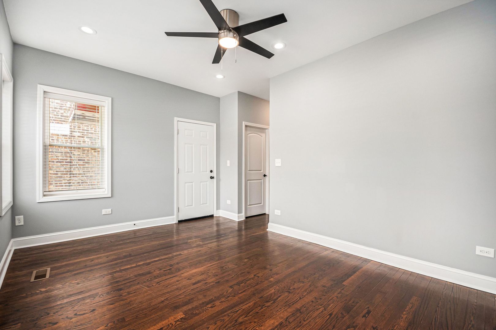 1702 North Meade Avenue, Unit 1 Chicago, IL 60639 - Photo 2 of 14 an empty room with wooden floor and windows