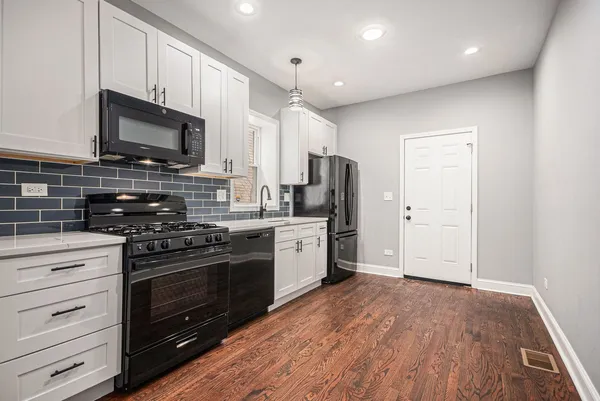 a kitchen with stainless steel appliances a stove microwave and refrigerator
