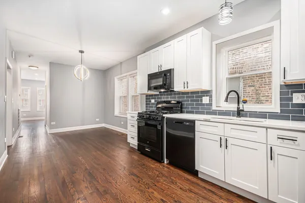 a kitchen with wooden floors appliances and cabinets