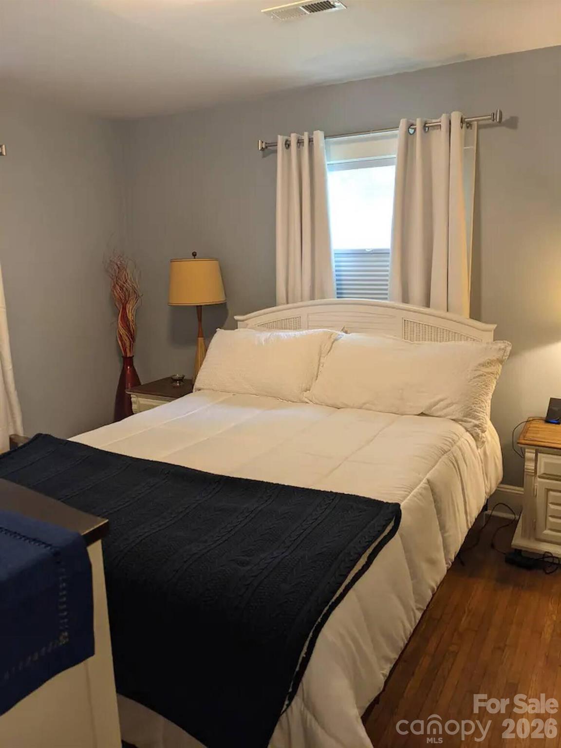 4033 West Tyvola Road Charlotte, NC 28208 - Photo 32 of 48 a bedroom with a bed and wooden floor