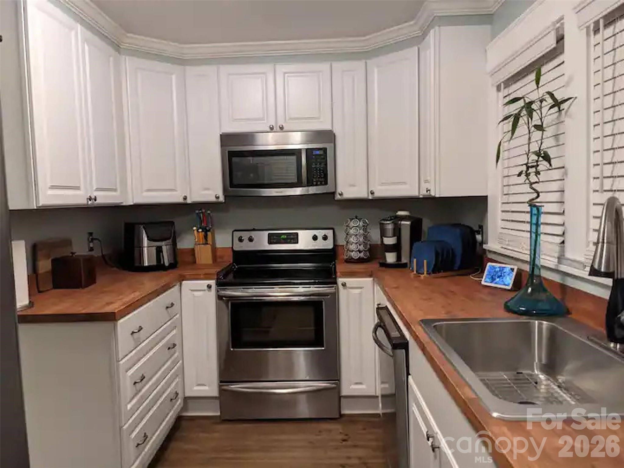 4033 West Tyvola Road Charlotte, NC 28208 - Photo 37 of 48 a kitchen with stainless steel appliances granite countertop a sink a stove and a microwave