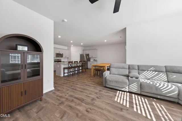 a living room with furniture and a view of kitchen