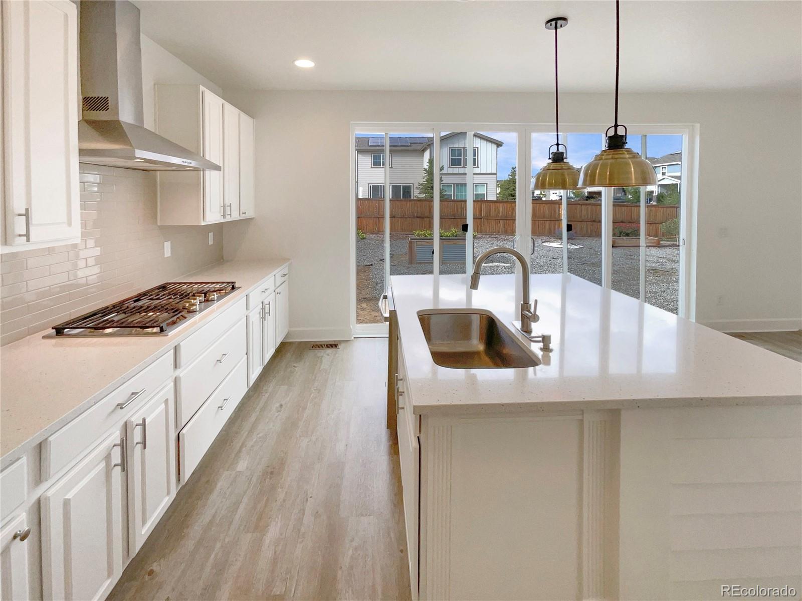 27895 East 7th Place Aurora, CO 80018 - Photo 15 of 35 a kitchen with stainless steel appliances granite countertop a sink a stove and a wooden floors