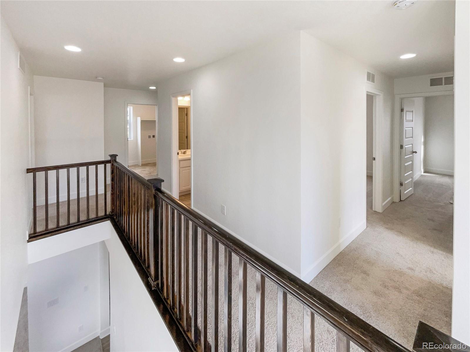 27895 East 7th Place Aurora, CO 80018 - Photo 16 of 35 a view of a hallway with wooden floor and staircase