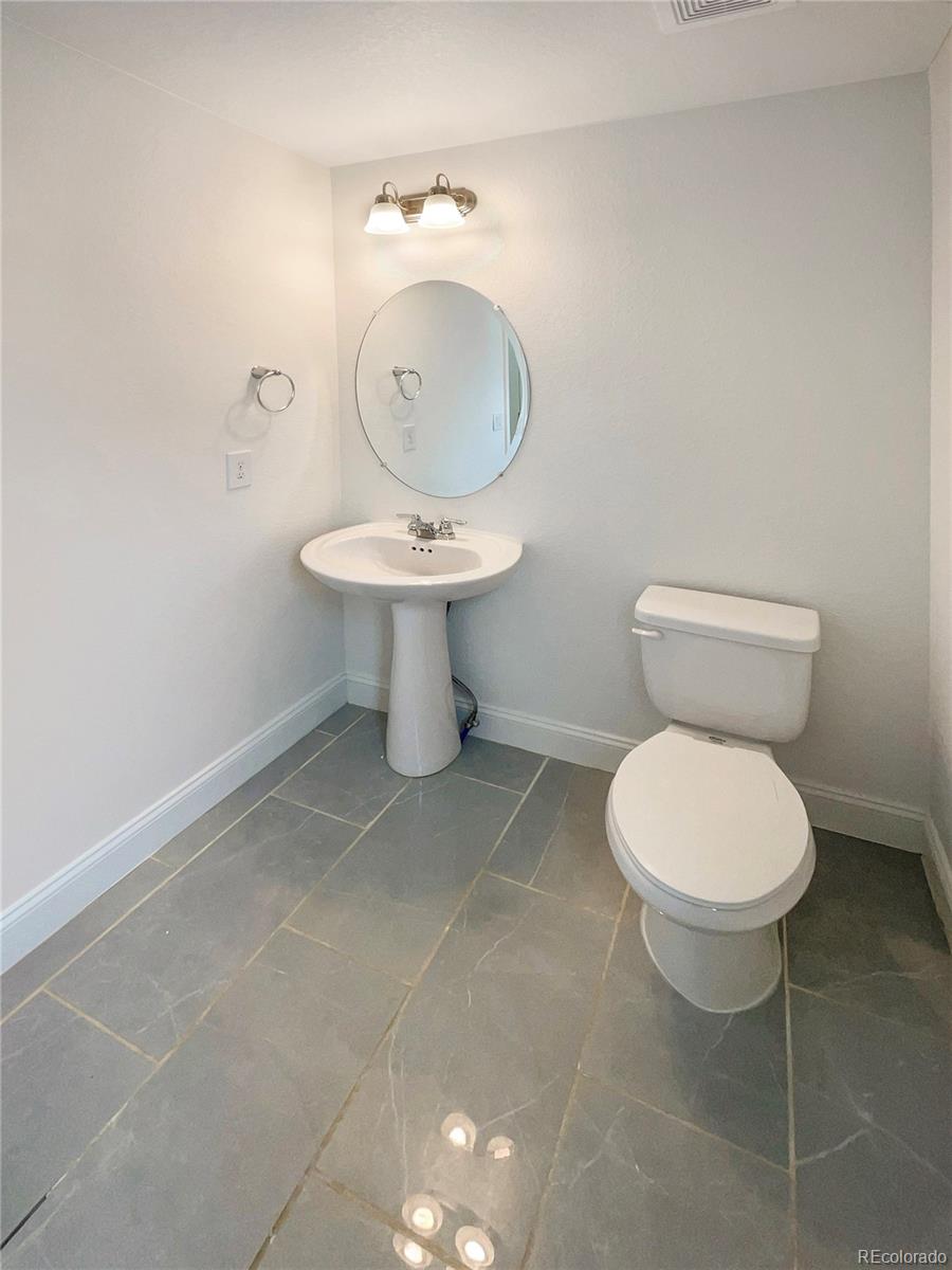 27895 East 7th Place Aurora, CO 80018 - Photo 7 of 35 a bathroom with a toilet and a sink