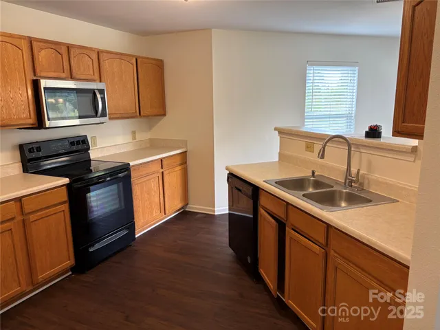 a kitchen with stainless steel appliances granite countertop a sink stove and microwave