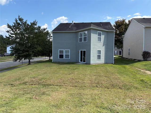 a view of a house with backyard and tree