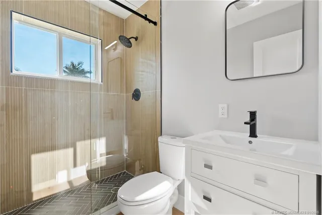 a bathroom with a sink a toilet and shower