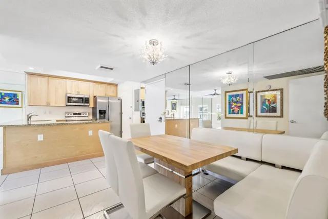 a kitchen with stainless steel appliances granite countertop a stove a sink a dining table and chairs