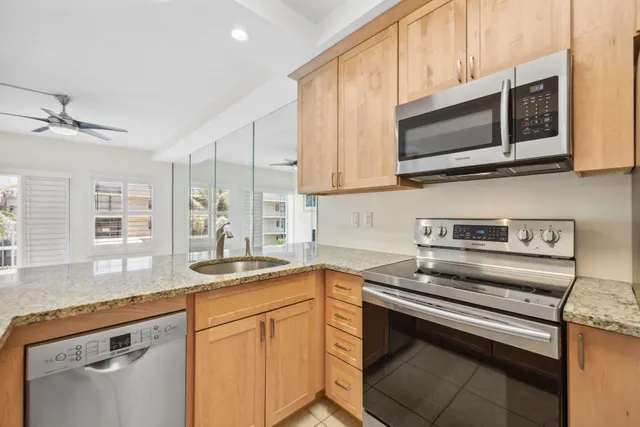 a kitchen with stainless steel appliances granite countertop a sink stove and microwave