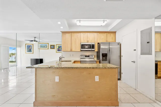 a view of a kitchen with stainless steel appliances granite countertop a refrigerator a stove and a sink