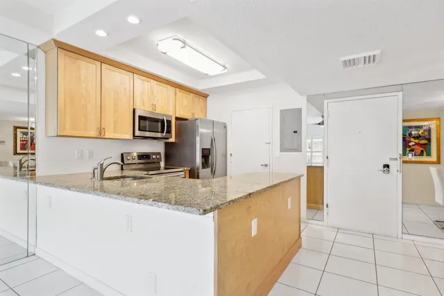 a kitchen with stainless steel appliances granite countertop a sink a stove a microwave a counter top and cabinets