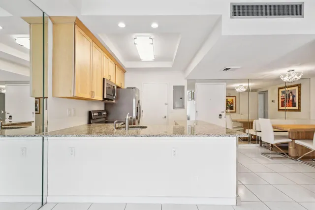 a large kitchen with kitchen island granite countertop a sink and cabinets