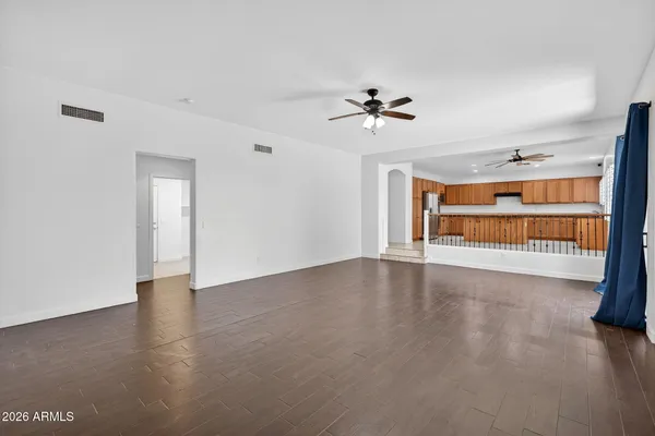 a view of empty room with wooden floor and ceiling fan