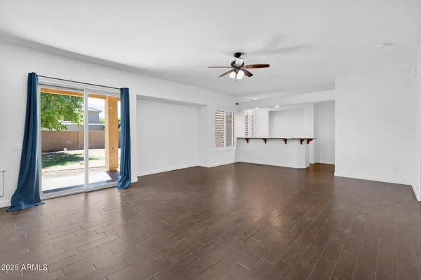 a view of empty room with wooden floor and ceiling fan