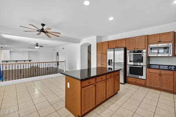 a kitchen with stainless steel appliances granite countertop a stove a sink and a refrigerator