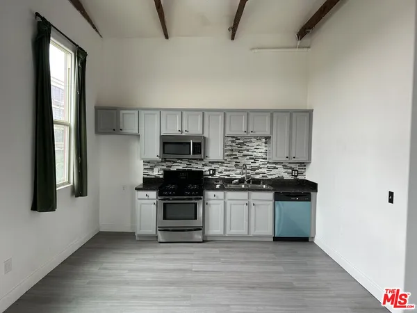 a kitchen with stainless steel appliances a stove a sink and a microwave