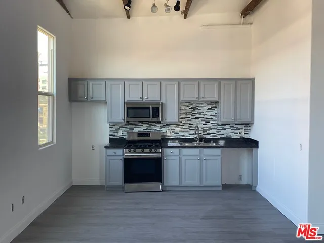 a kitchen with stainless steel appliances a stove a sink and a microwave