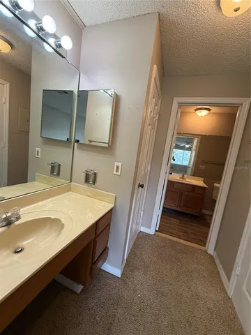 a en suite bathroom with a sink and a large mirror