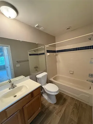 a bathroom with a double vanity sink a toilet a mirror and shower
