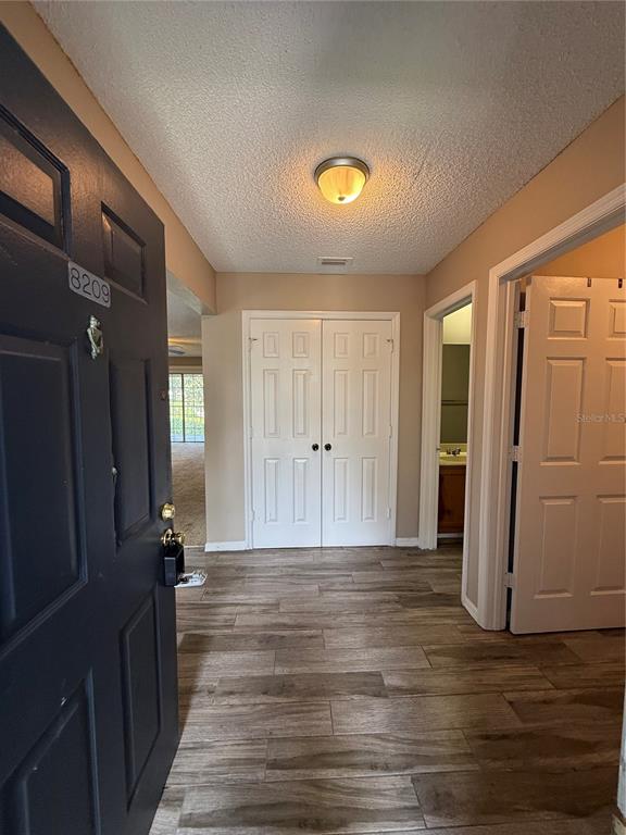 8209 Olympia Court Longwood, FL 32779 - Photo 3 of 29 a view of a hallway with wooden floor and closet area