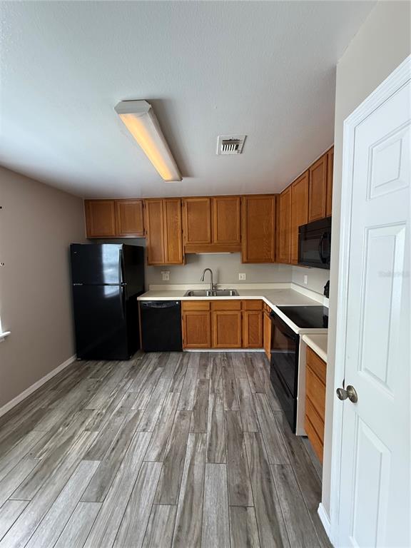 8209 Olympia Court Longwood, FL 32779 - Photo 7 of 29 a kitchen with stainless steel appliances wooden floors a refrigerator a sink a stove a microwave and wooden floors