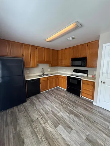 a kitchen with wooden floors and wooden cabinets
