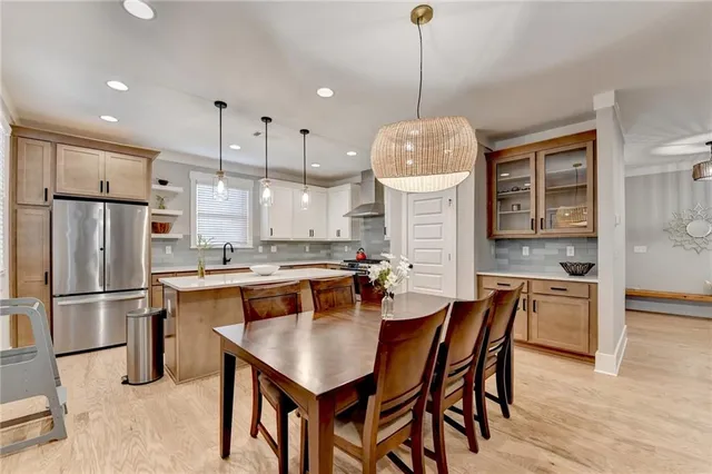 a kitchen with a dining table chairs sink and cabinets