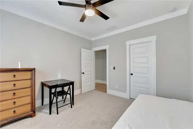 a bedroom with a bed and a chandelier fan