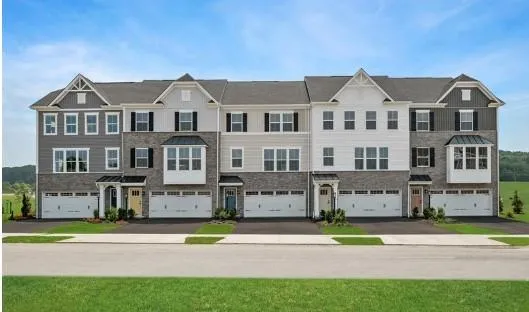 a view of an white house with a big yard and large trees