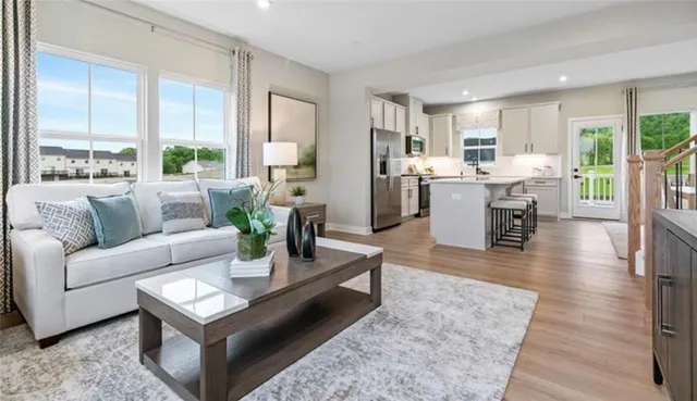 a living room with furniture wooden floor and a large window