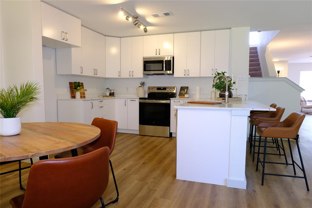 3437 Caprock Ranch Road Fort Worth, TX 76262 - Photo 7 of 27 a kitchen with furniture wooden floor and stainless steel appliances