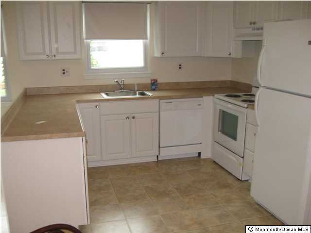 19 Patmore Road Brick, NJ 08724 - Photo 2 of 3 a kitchen with granite countertop white cabinets and white appliances