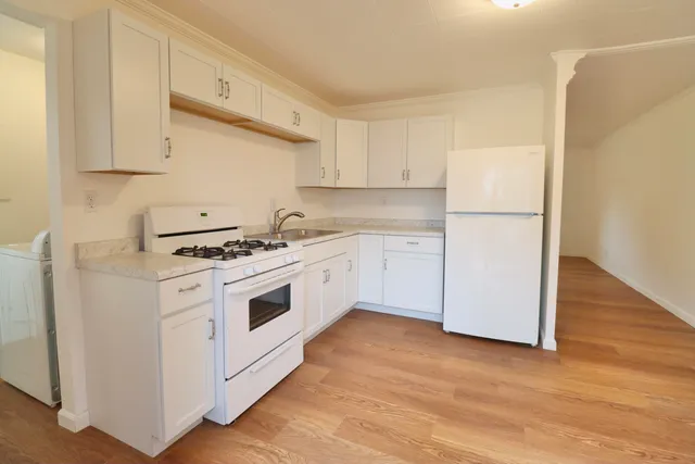 a kitchen with cabinets appliances a sink and a counter space