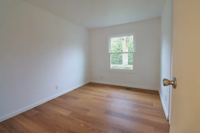 a view of an empty room with wooden floor