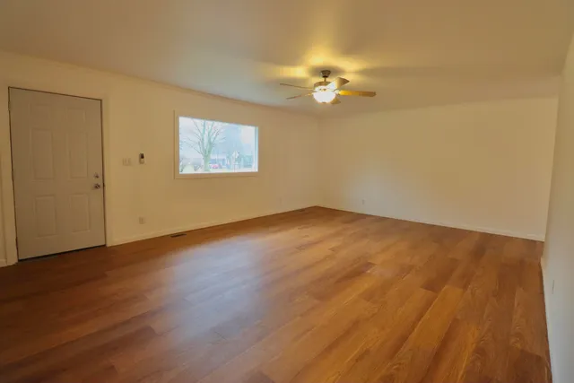 a view of an empty room with wooden floor