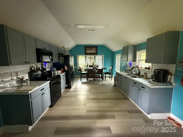 a large kitchen with stainless steel appliances lots of counter space and a sink