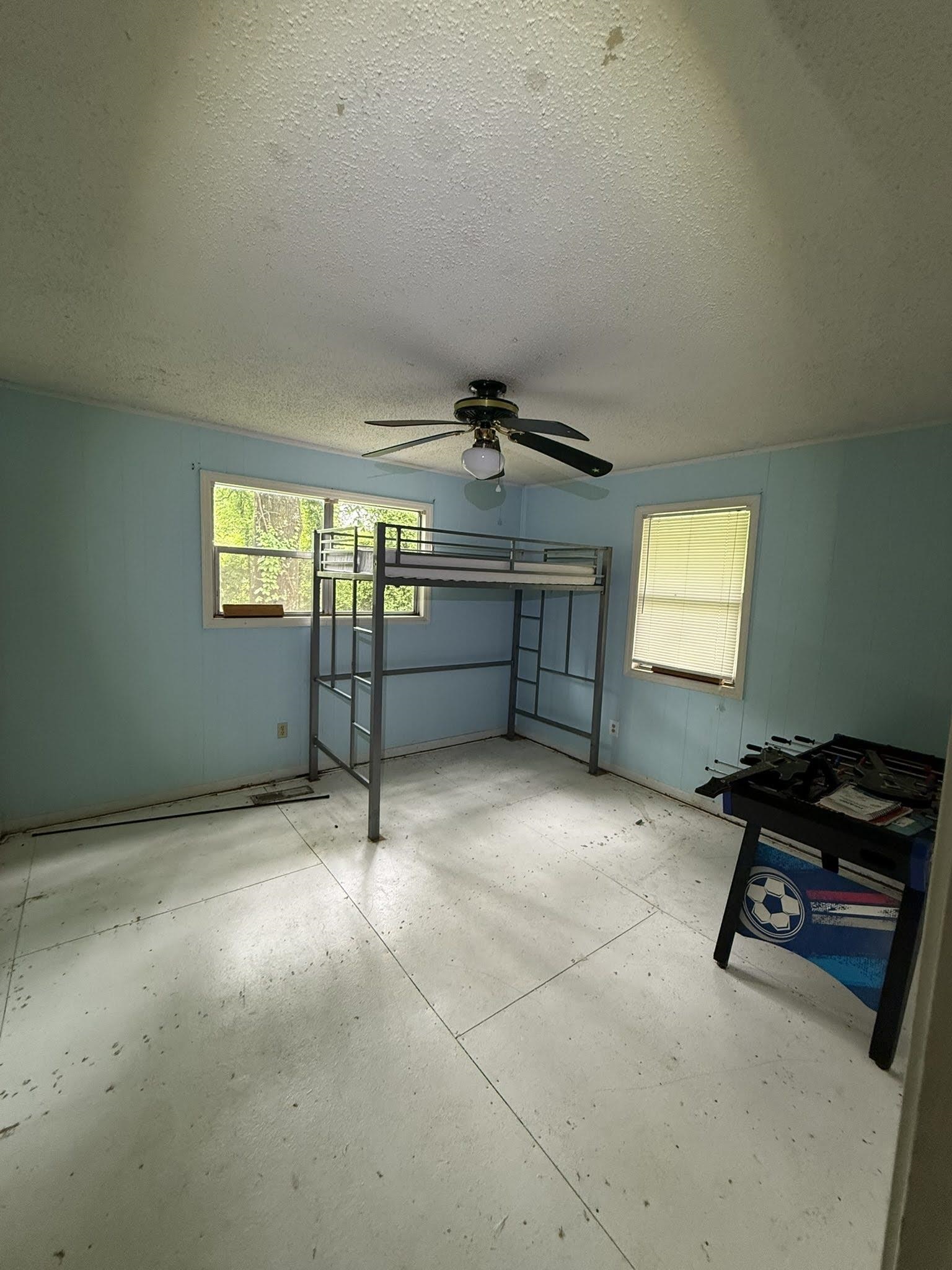 1299 Locke Cuba Road Millington, TN 38053 - Photo 17 of 28 Interior space featuring light blue walls, two windows, a ceiling fan with integrated lighting, and light-colored panel flooring