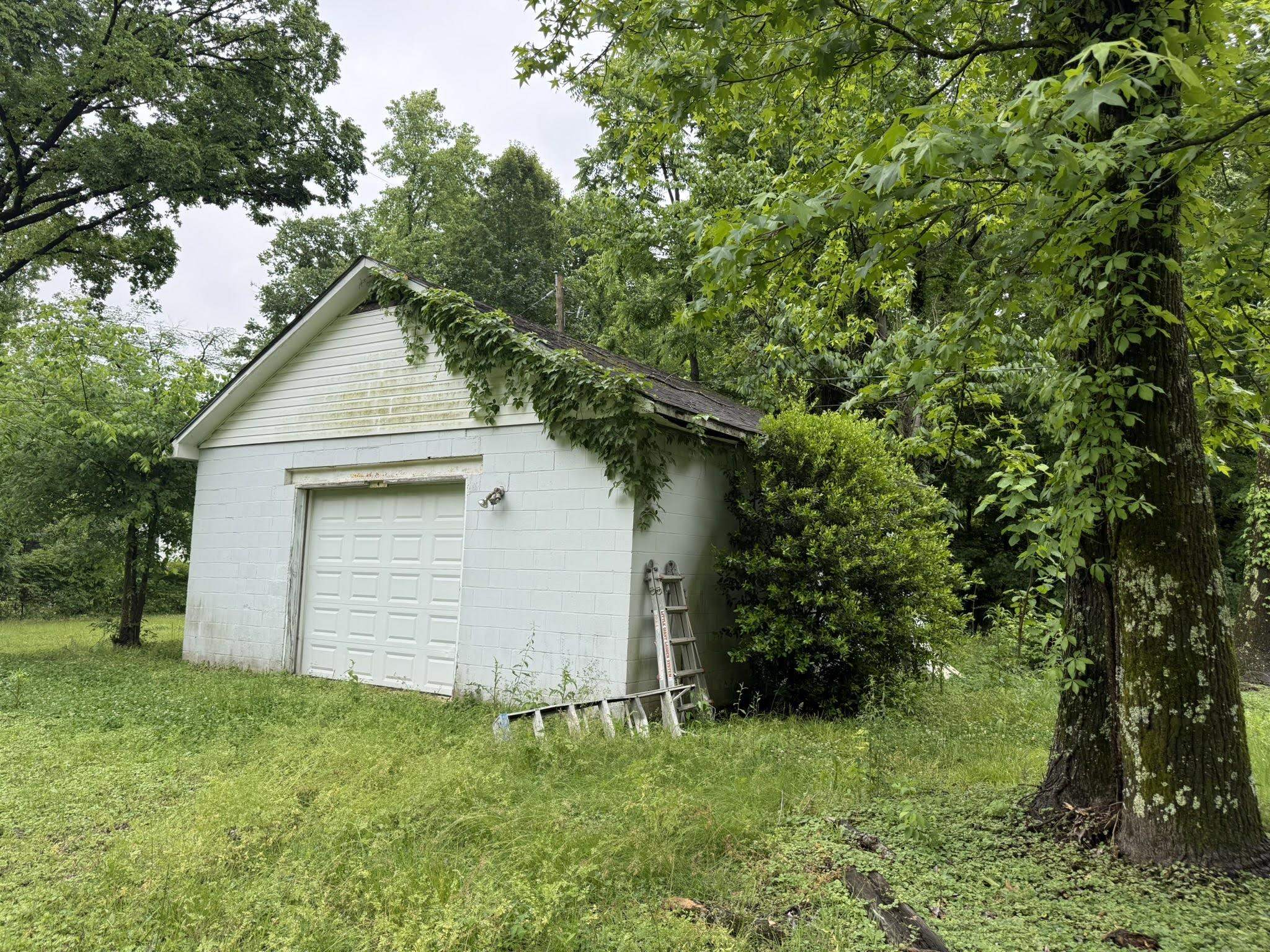 1299 Locke Cuba Road Millington, TN 38053 - Photo 23 of 28 Detached garage structure featuring a paneled garage door and a gable roofline