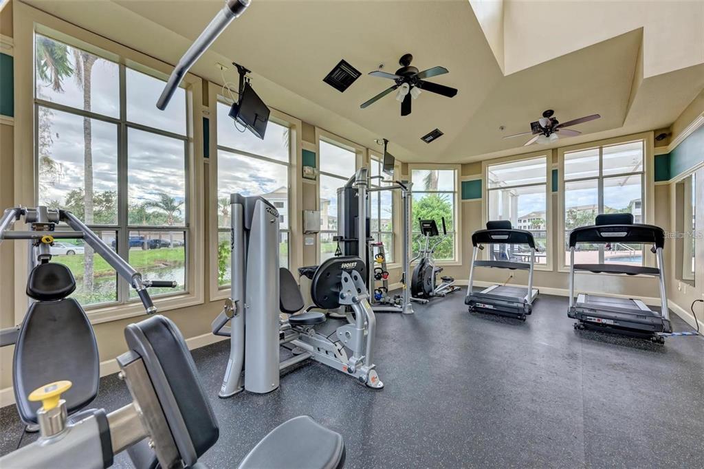4802 51st Street West, Unit 1418 Bradenton, FL 34210 - Photo 17 of 20 a view of a livingroom with furniture water floor to ceiling windows and a ceiling fan