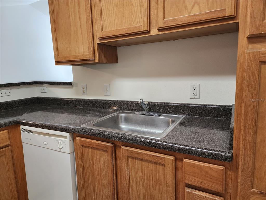 4802 51st Street West, Unit 1418 Bradenton, FL 34210 - Photo 4 of 20 a kitchen with granite countertop stainless steel appliances a sink and cabinets