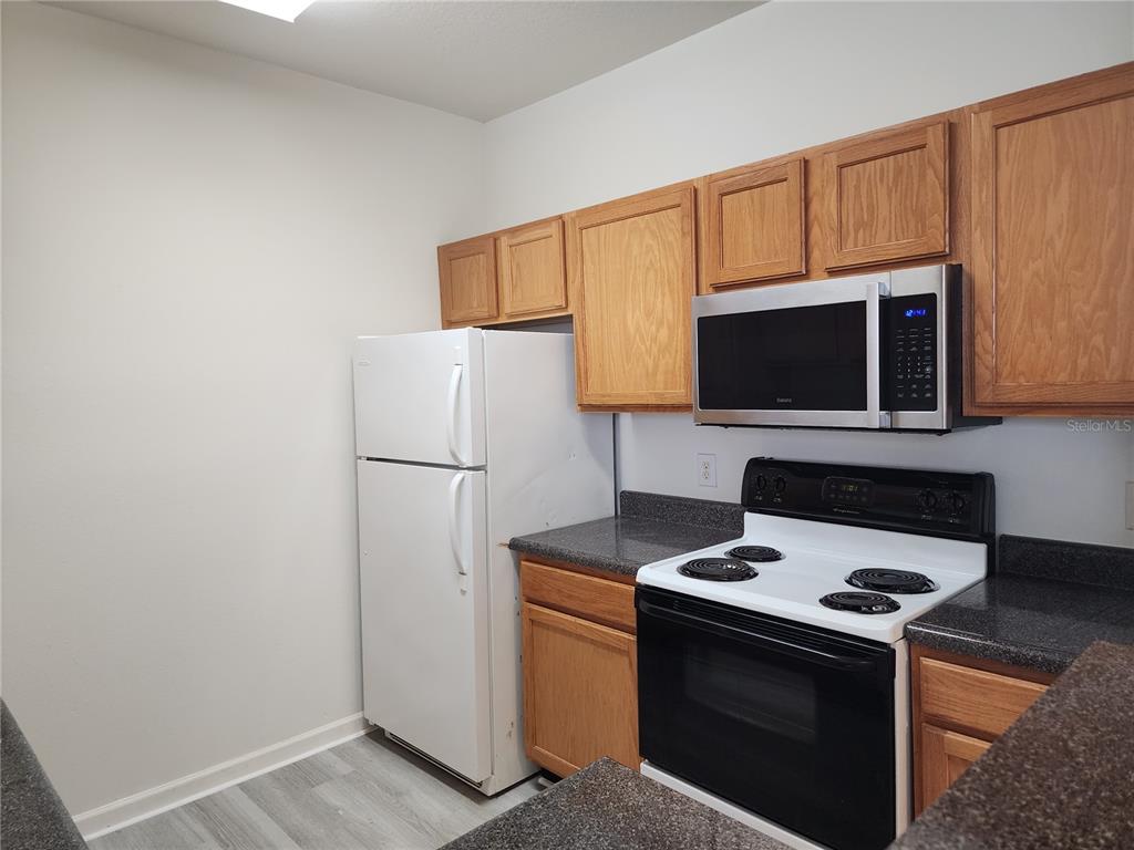 4802 51st Street West, Unit 1418 Bradenton, FL 34210 - Photo 5 of 20 a kitchen with a stove microwave and refrigerator
