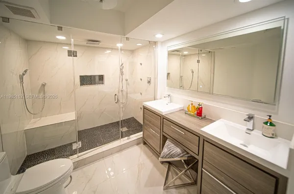 a bathroom with a sink a toilet and shower